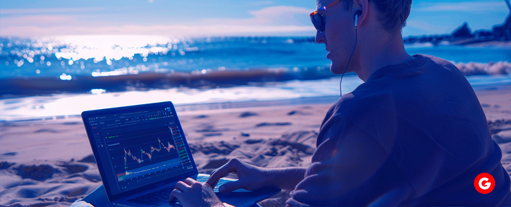 A man sitting on the beach with his laptop, engaging in part time forex trading