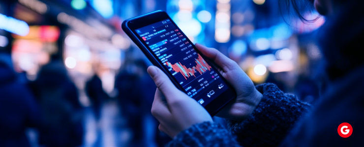 A person views a stock market graph on their smartphone, illustrating real-time financial data and market performance.